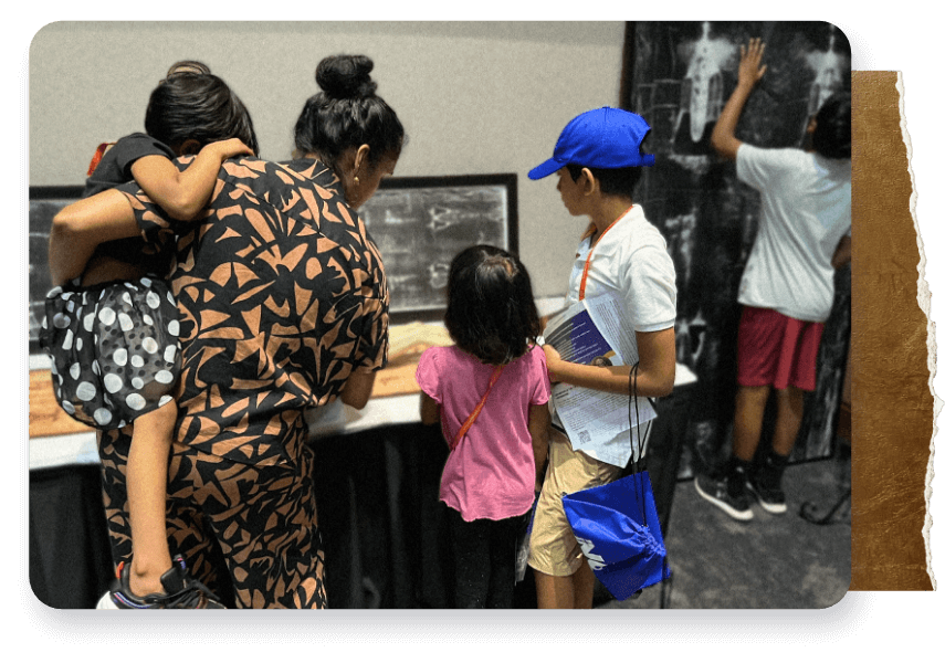 Madre con bambini che guardano la mostra.